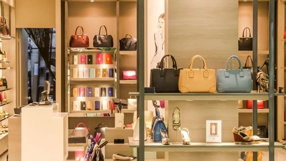 A store display featuring a variety of handbags in different styles, colors, and sizes arranged neatly on shelves.