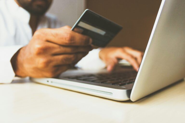 man holding credit card and laptop