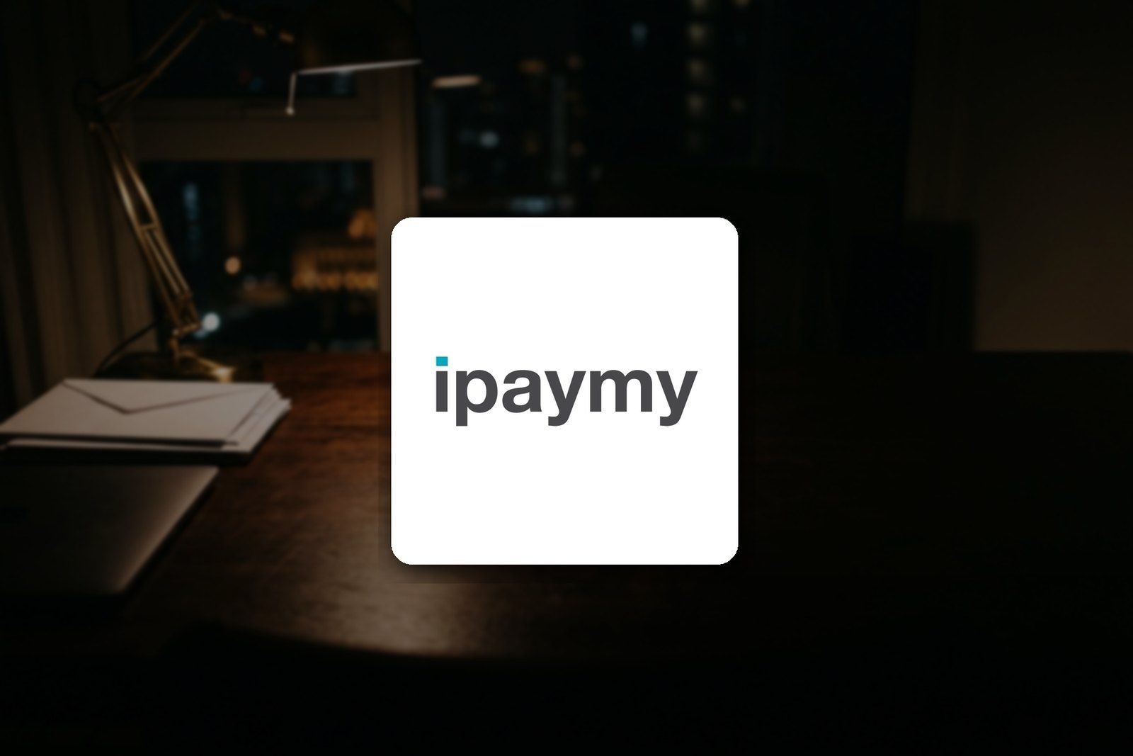 iPayMy logo on a desk at night, for a guide to paying rent, insurance and taxes by credit card