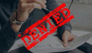 word denied and a man holding a paper