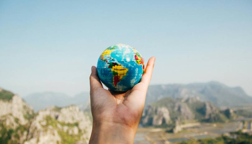 person holding miniature globe